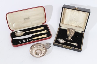 Lot 380 - Elizabeth II silver wine taster of circular form, with embossed decoration and moulded vine leaf to handle (Birmingham 1986), together with a silver egg cup and plated spoon in fitted case and a th...