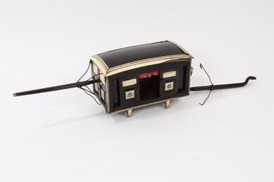 Lot 872 - Rare 19th century Indian horn and ivory model of a Palanquin with red velvet lining , sliding doors, shutters, lamp and carrying poles. The body 17cm long excluding poles