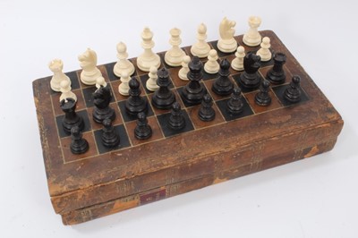 Lot 875 - Victorian leather covered folding chess and backgammon board in the form of a two volume book, together with a complete turned and carved ivory and ebony chess set