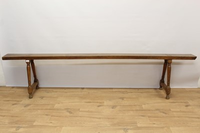 Lot 1364 - Rare pair of 19th century fruitwood joined benches, narrow single plank top on splayed turned supports and bun feet, 237cm long