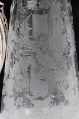 Lot 395 - Victorian glass claret jug of tapered form, with etched decoration of a cross amongst Holly and birds, silver plated mount with engraved scroll decoration, Bacchus mask and domed hinged cover, 29cm...