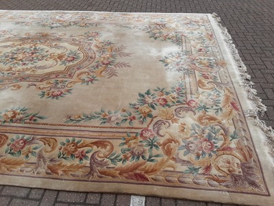 Lot 238 - Large Chinese carpet with floral decoration on beige ground, 558cm x 364cm