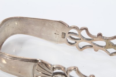 Lot 305 - Pair of George III silver sugar tongs with pierced and engraved decoration, London circa. 1775, maker William Chatterton 12.5cm overall, together with another three pairs of similar Georgian silver...