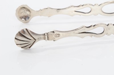 Lot 308 - Pair of Edwardian silver sugar tongs with pierced and engraved decoration, (Sheffield 1907), 11cm overall, together with another four pairs of similar silver sugar tongs, (various dates and makers)...