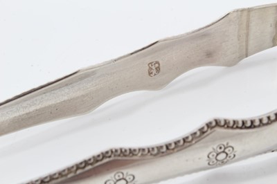 Lot 309 - Pair of George III silver sugar tongs with engraved decoration, (London 1782), 12.5cm overall, together with another two pairs of silver sugar tongs, (various dates and makers) (3)