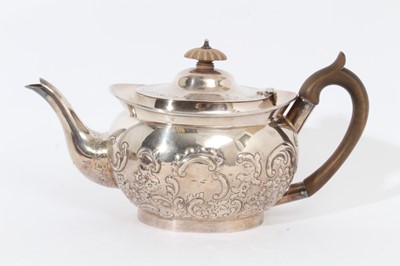 Lot 339 - Edwardian silver teapot of cauldron form with embossed floral and scroll decoration