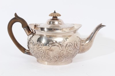 Lot 339 - Edwardian silver teapot of cauldron form with embossed floral and scroll decoration