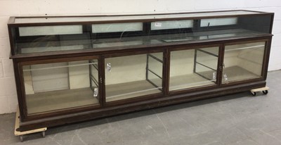 Lot 1336 - Very large early 20th century shop counter, the upper section accessed by four rear hinged doors, the base with four glazed doors, 322cm wide x 59cm deep x 105cm high