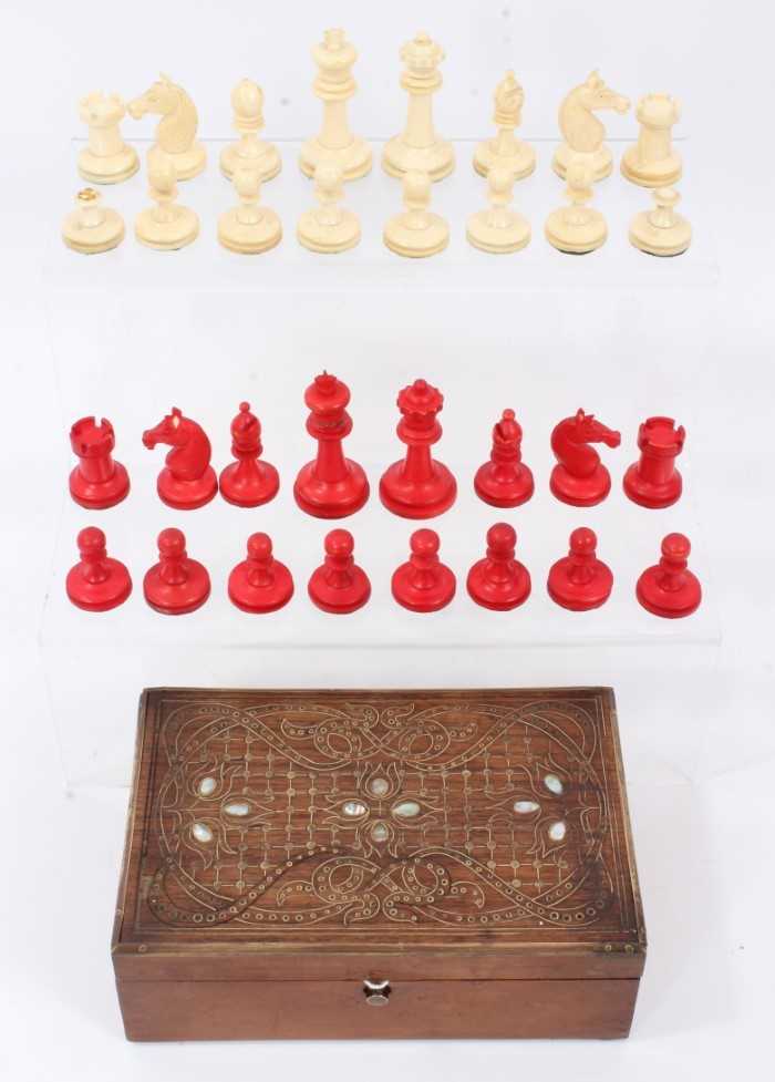 Lot 881 - Antique bone and red stained bone chess set in associated brass and mother of pearl inlaid box