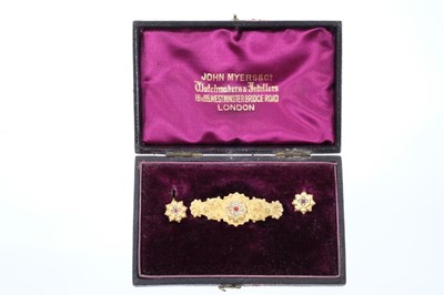 Lot 561 - Pair of Victorian 9ct gold earrings and brooch en-suite, the target shape cluster earrings set with a garnet and seed pearls, the matching bar brooch with applied floral decoration and locket compa...