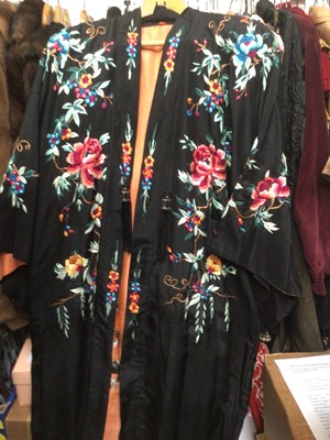 Lot 1901 - Chinese black silk robe with polychrome silk embroidered flowers, reversible orange silk with flowers.