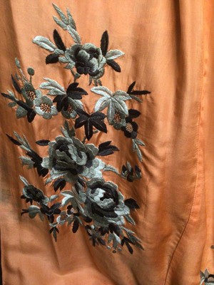 Lot 1901 - Chinese black silk robe with polychrome silk embroidered flowers, reversible orange silk with flowers.