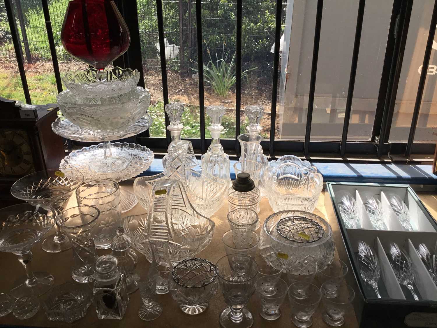 Lot 200 - Collection of cut glass and pressed glass wares to include decanters, cake stands and other pieces