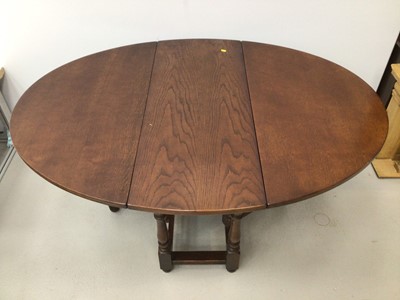 Lot 25 - Oak oval drop leaf dining table and a set of six oak wheelback chairs