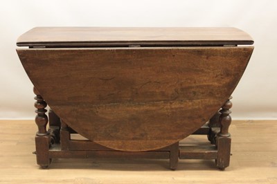 Lot 1070 - 17th and later oak and walnut drop-leaf dining table, with oval hinged top and end frieze drawer on turned and block understructure, 122 x 155cm