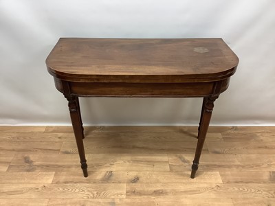 Lot 1067 - Regency mahogany and line inlaid D-shaped fold over card table, with green baize lined playing surface on ring turned tapered legs, 83cm wide