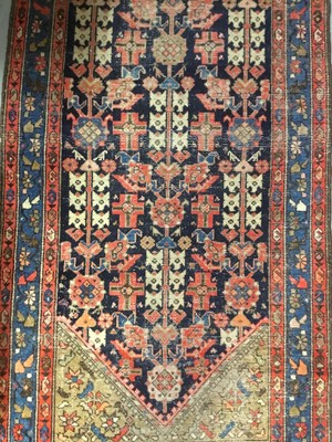 Lot 1374 - Antique Eastern runner with geometric medallions, on red and blue ground, 400cm x 100cm