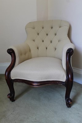 Lot 1383 - Victorian mahogany framed arm chair with buttoned cream upholstery, on scroll carved legs terminating on castors