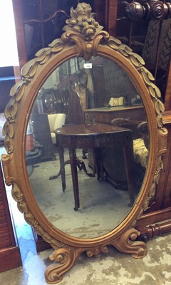 Lot 1360 - Gilt wall mirror, the oval plate in foliate surround, 137cm high x 85cm wide