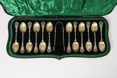 Lot 314 - Set of twelve late Victorian silver gilt teaspoons and matching tongs, in original fitted case