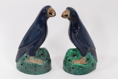 Lot 105 - Pair of Chinese blue-glazed pottery parrots, late Qing period, modelled on naturalistic green bases, 22cm and 22.5cm high, together with a Chinese blue-glazed model of a foo dog (3)