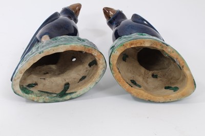 Lot 105 - Pair of Chinese blue-glazed pottery parrots, late Qing period, modelled on naturalistic green bases, 22cm and 22.5cm high, together with a Chinese blue-glazed model of a foo dog (3)