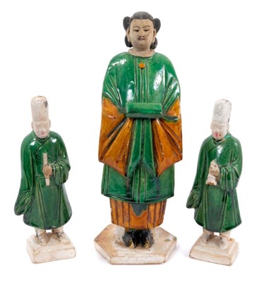 Lot 106 - Three Chinese Sancai-glazed pottery figures, probably Ming dynasty, including a pair of smaller male attendants, 22.5cm high, and a larger female figure, 33.5cm high