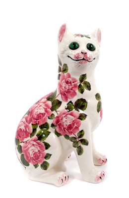 Lot 116 - Wemyss pottery cat, painted with pink cabbage roses, with inset green glass eyes, inscribed marks to base, signed B. Adams, 33cm high