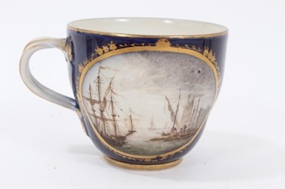 Lot 121 - Four 18th century continental porcelain cups, various marks including crossed swords and interlaced L's, one cup finely painted with a landscape and seascape on a cobalt ground, another with birds...