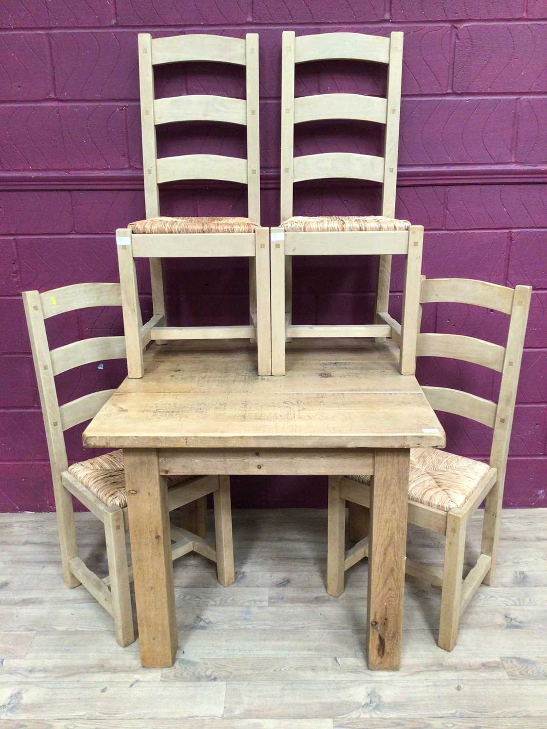Lot 359 - Contemporary light oak dining table and four matching ladder back chairs with rush seats