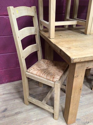 Lot 359 - Contemporary light oak dining table and four matching ladder back chairs with rush seats