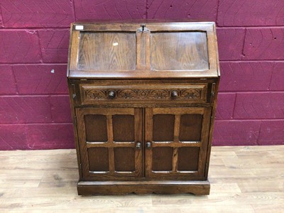 Lot 323 - Oak two height bookcase with leaded glazed doors above, drawers and linenfold panelled doors below, plus an oak bureau