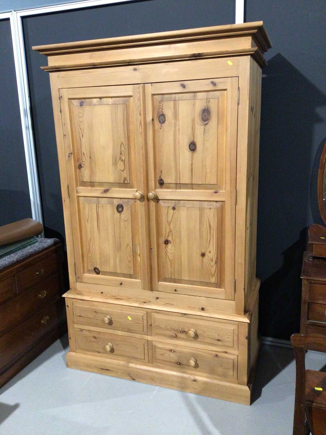 Lot 3 - Modern pine double wardrobe with two panelled doors and four short drawers below, 128cm wide x 63cm deep x 208cm high