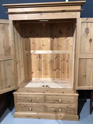 Lot 3 - Modern pine double wardrobe with two panelled doors and four short drawers below, 128cm wide x 63cm deep x 208cm high