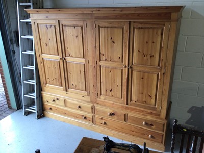 Lot 9 - Modern pine triple wardrobe wiht three panelled doors, three short and two long drawers below, 184cm wide x 59cm deep x 199cm high plus a pine four door wardrobe and a cheval mirror
