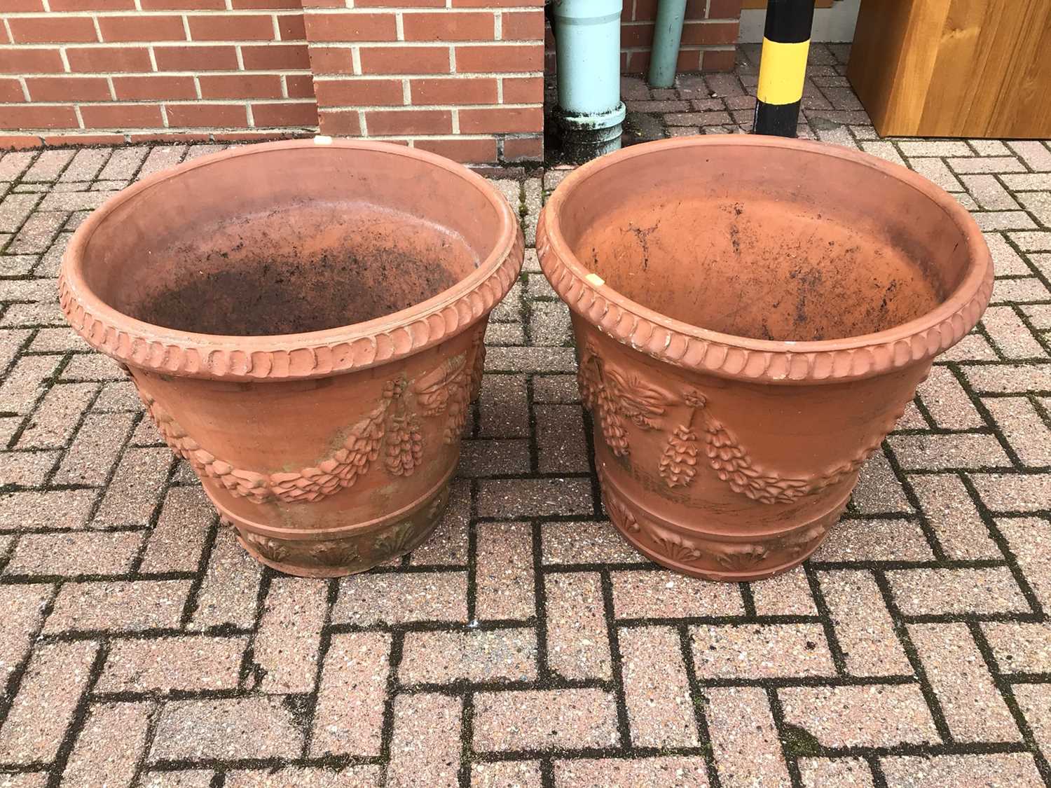 Lot 54 - Pair of large terracotta garden urns with wreath decoration 51cm x 58cm