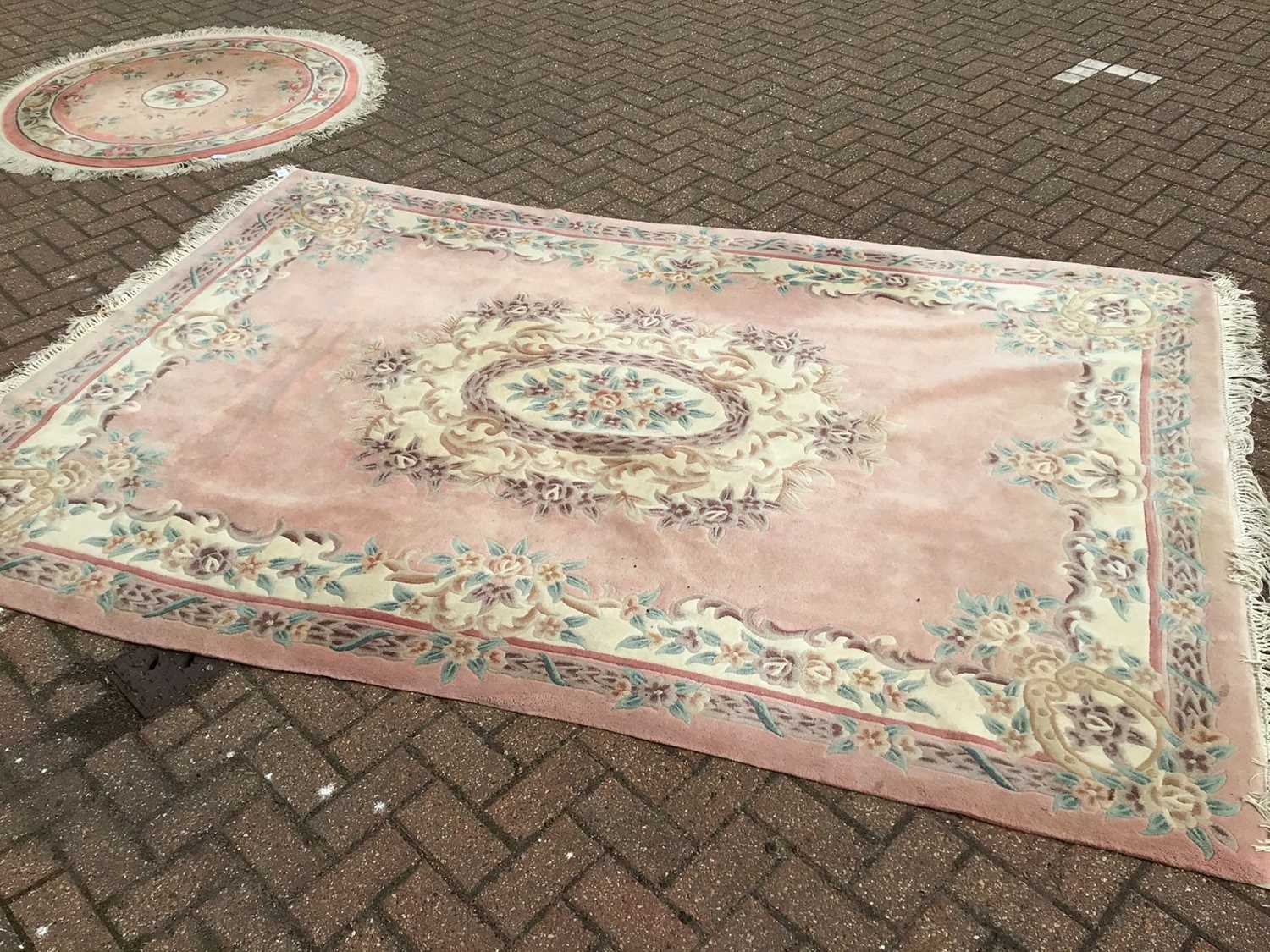 Lot 66 - Chinese wash rug with floral decoration on peach ground 274cm x 186cm with a smaller round rug of similar description 134cm
