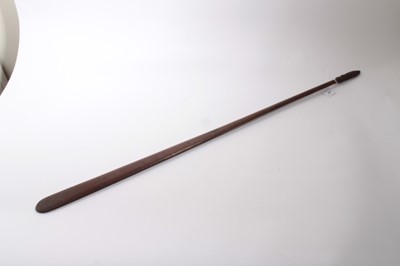 Lot 867 - 19th century Maori Taiaha club with arched tapered end and finely carved scroll decoration with mask,  Length 102 cm.