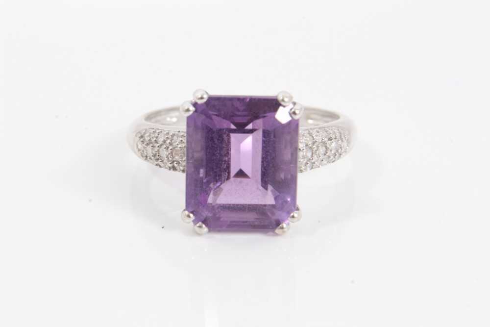 Lot 111 - 14ct white gold purple stone cocktail ring with diamond set shoulders