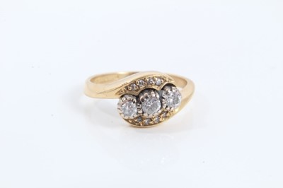 Lot 112 - 18ct gold diamond three stone ring in diamond set crossover setting