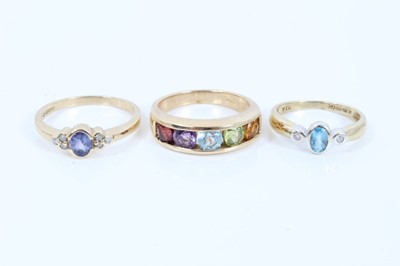 Lot 114 - Two 9ct gold oval blue stone rings with diamond set shoulders and 9ct gold five stone multi gem ring (3)