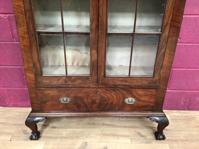 Lot 389 - Edwardian mahogany bookcase with shelved interior enclosed by two glazed doors with drawer below on carved cabriole legs with claw and ball feet, 106.5cm wide, 34cm deep, 200.5cm high