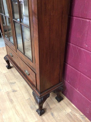 Lot 389 - Edwardian mahogany bookcase with shelved interior enclosed by two glazed doors with drawer below on carved cabriole legs with claw and ball feet, 106.5cm wide, 34cm deep, 200.5cm high