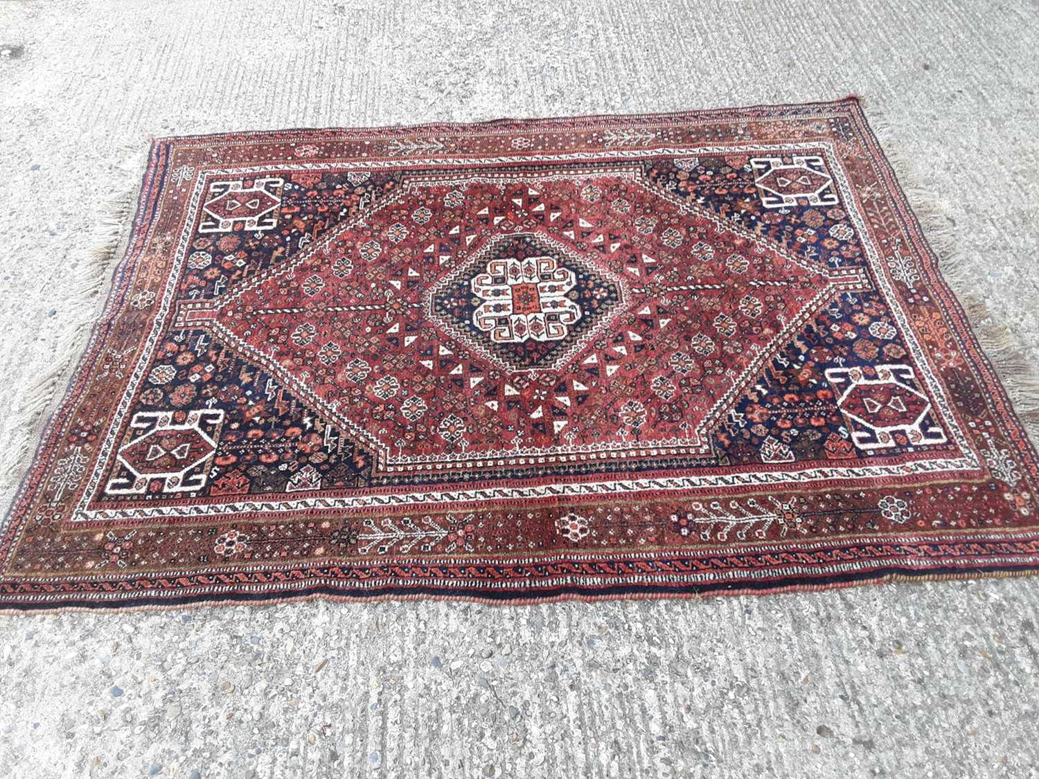 Lot 394 - Eastern rug with geometric decoration on red and blue ground, 199cm x 148cm