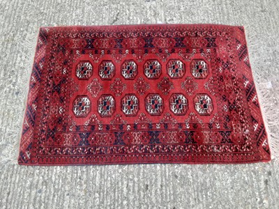 Lot 395 - Eastern rug with geometric decoration on red ground, 120cm x 82cm