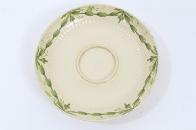 Lot 209 - Leeds creamware tea cup and saucer, c.1780, semi-fluted form, the cup with double strap handle, painted in green enamel with foliate swags, the saucer measuring 12cm diameter