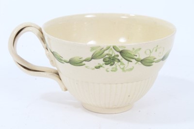Lot 191 - Leeds creamware tea cup and saucer, c.1780, semi-fluted form, the cup with double strap handle, painted in green enamel with foliate swags, the saucer measuring 12cm diameter
