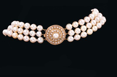 Lot 542 - Cultured pearl three-strand choker with three strings of baroque cultured pearls measuring approximately 8.5mm diameter on a large 14k gold and cultured pearl clasp.