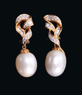 Lot 545 - Pair of cultured pearl and diamond pendant earrings, each with a large cultured pearl drop measuring approximately 16mm x 12.5mm suspended from an 18ct gold ribbon scroll with baguette cut and bril...