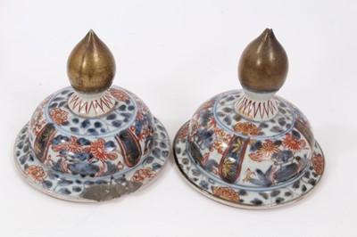 Lot 254 - Near pair of Japanese Edo period Imari vases and covers, decorated with landscapes and flowers, 26.5cm and 28cm high